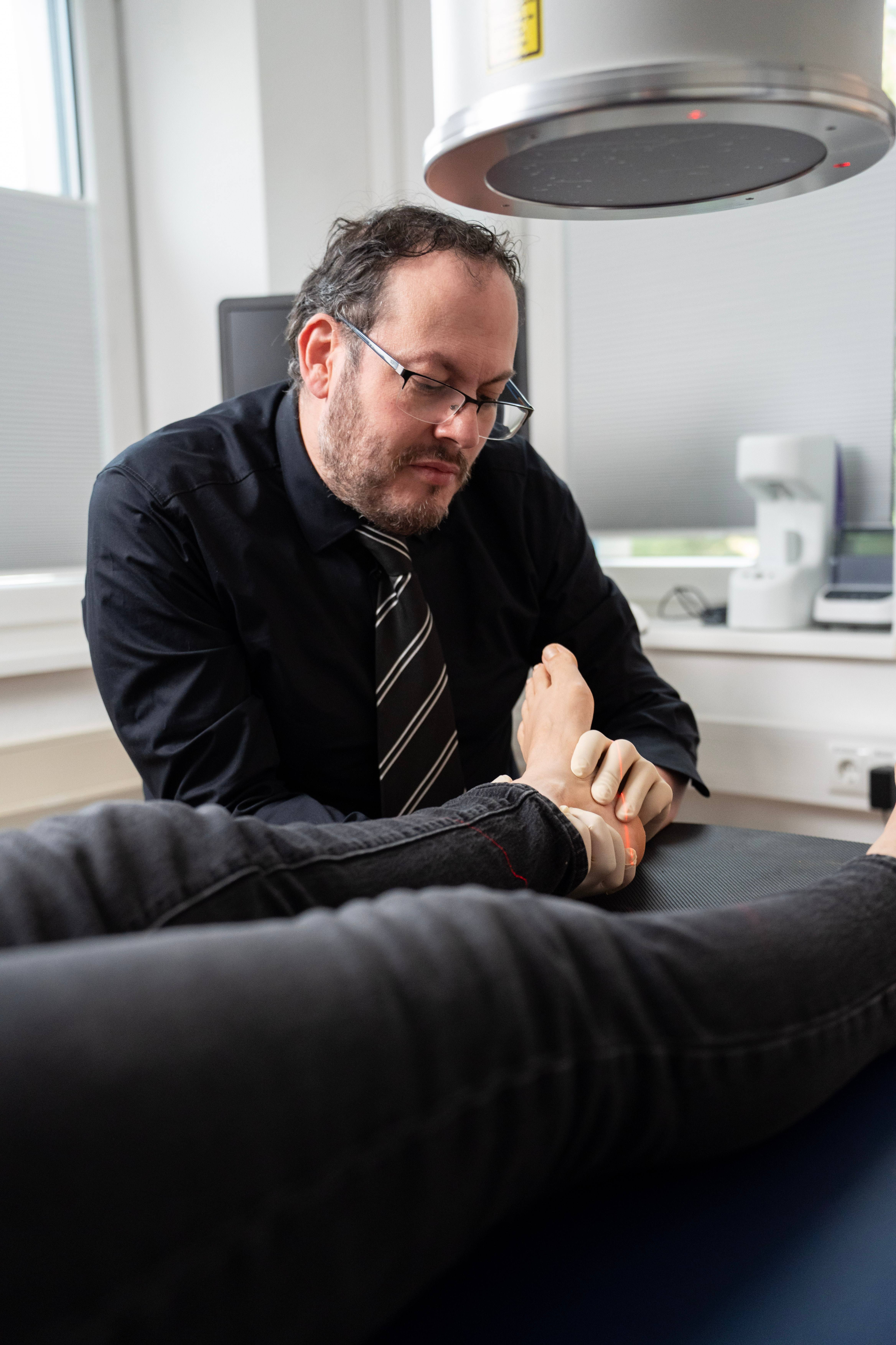 Dr. Velickovic positioniert den Fuß einer Patientin unter dem Röntgengerät