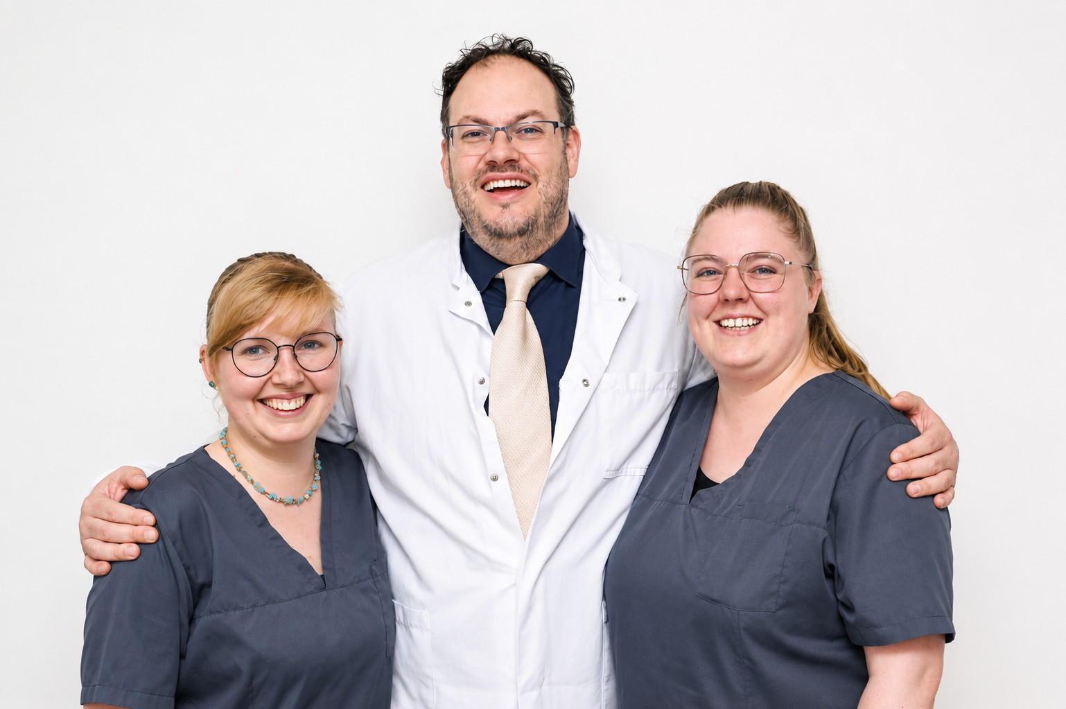 Dr. med. Mirko Velickovic mit zwei medizinischen Fachangestellten vor der Praxis-Logowand